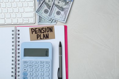 Photo of Card with words Pension Plan, banknotes, calculator and notebook on white office table, flat lay. Space for text