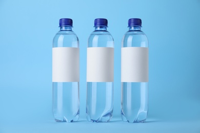 Photo of Plastic bottles with soda water on light blue background