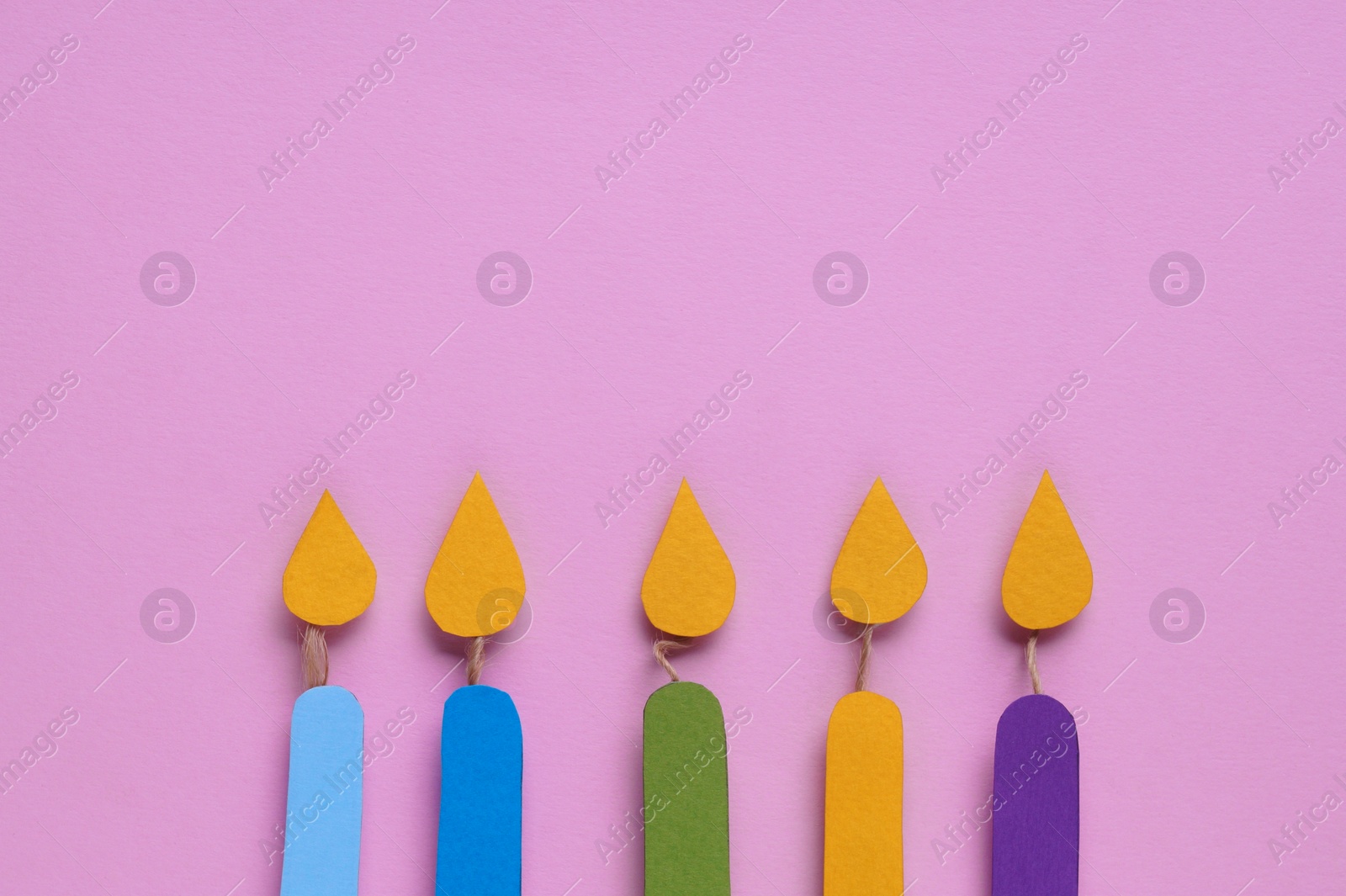 Photo of Different paper candles on pink background, flat lay. Space for text