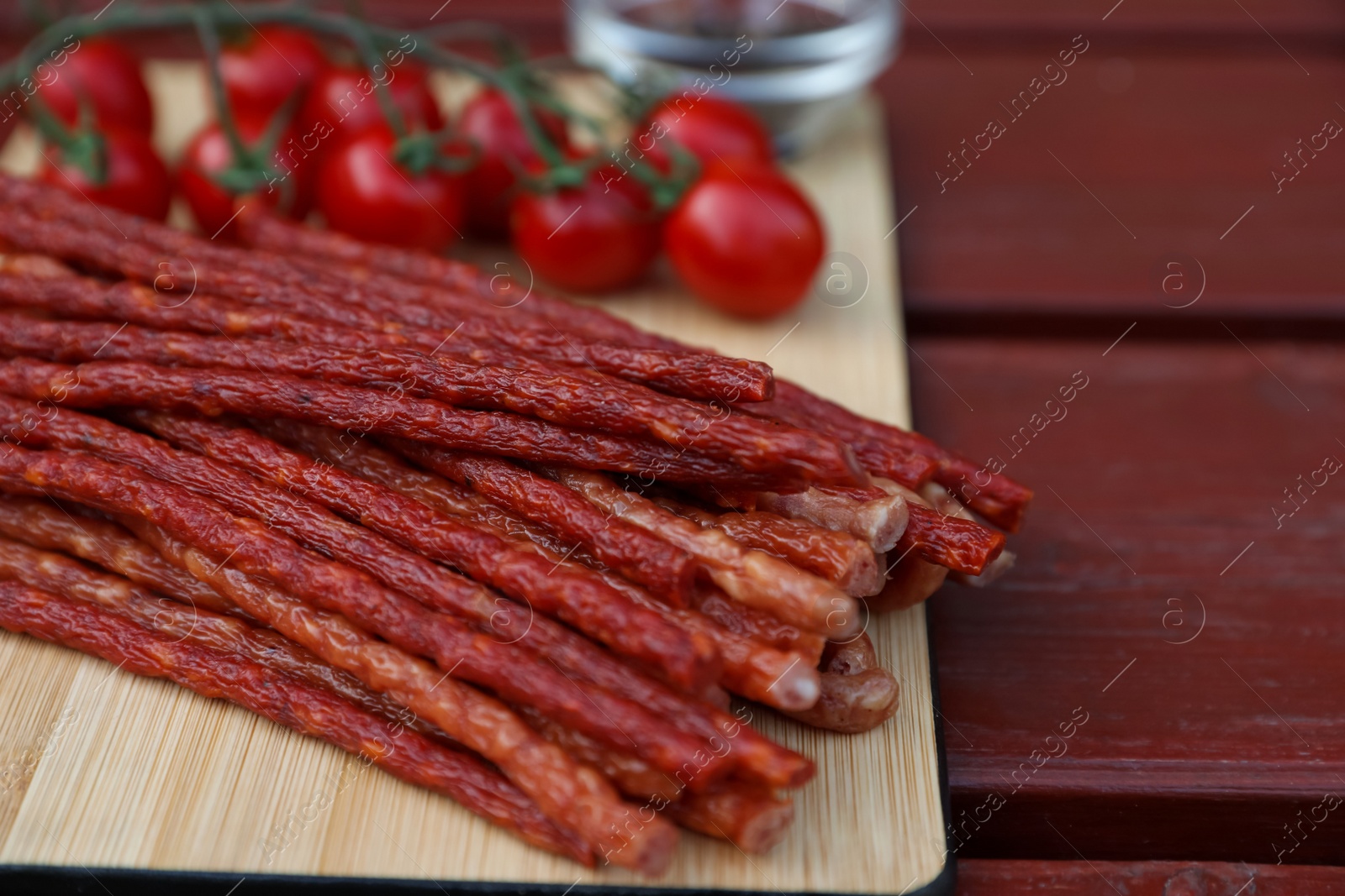 Photo of Tasty dry cured sausages (kabanosy) on wooden table, closeup