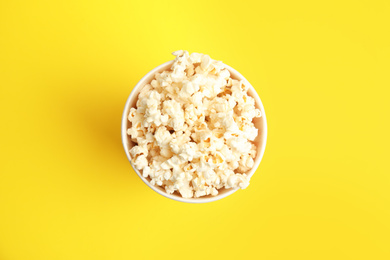 Photo of Tasty pop corn on yellow background, top view