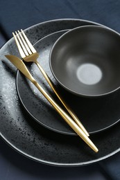 Stylish ceramic plates, bowl and cutlery on table