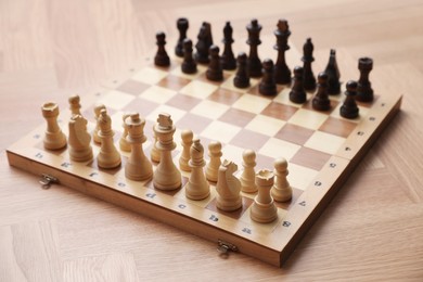 Chess board with pieces on wooden table