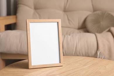 Photo of Empty square frame on wooden table indoors, space for text