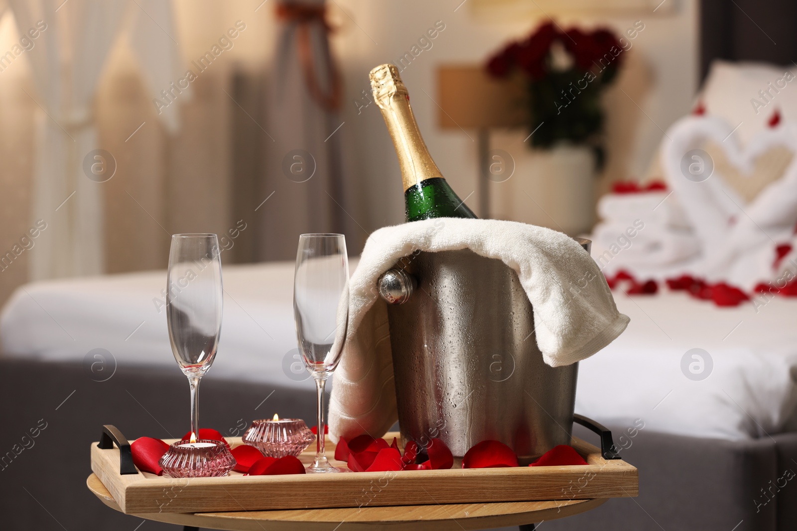 Photo of Honeymoon. Sparkling wine and glasses on wooden table in room