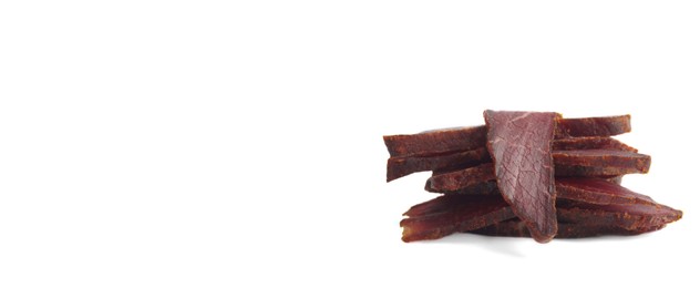 Image of Pieces of delicious beef jerky on white background. Banner design
