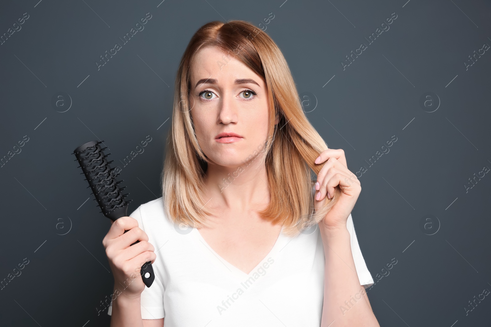 Photo of Young woman with hair loss problem on gray background