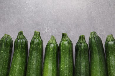 Raw ripe zucchinis on light grey table, flat lay. Space for text