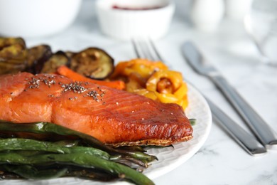Photo of Tasty cooked salmon and vegetables served on white table, closeup. Healthy meals from air fryer