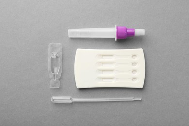 Photo of Disposable express test kit on grey background, flat lay