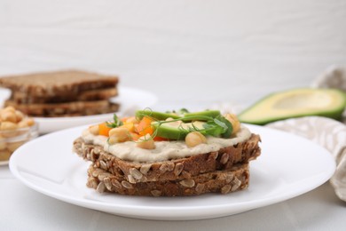 Photo of Tasty vegan sandwich with avocado, chickpeas and bell pepper on white table, closeup