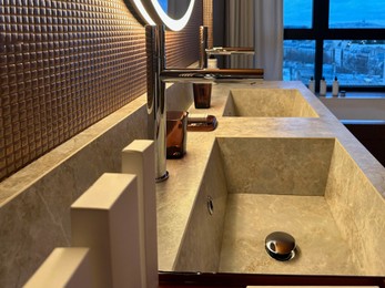 Photo of Modern sinks and faucets in hotel bathroom