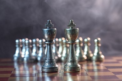 Kings in front of pawns on chessboard, selective focus