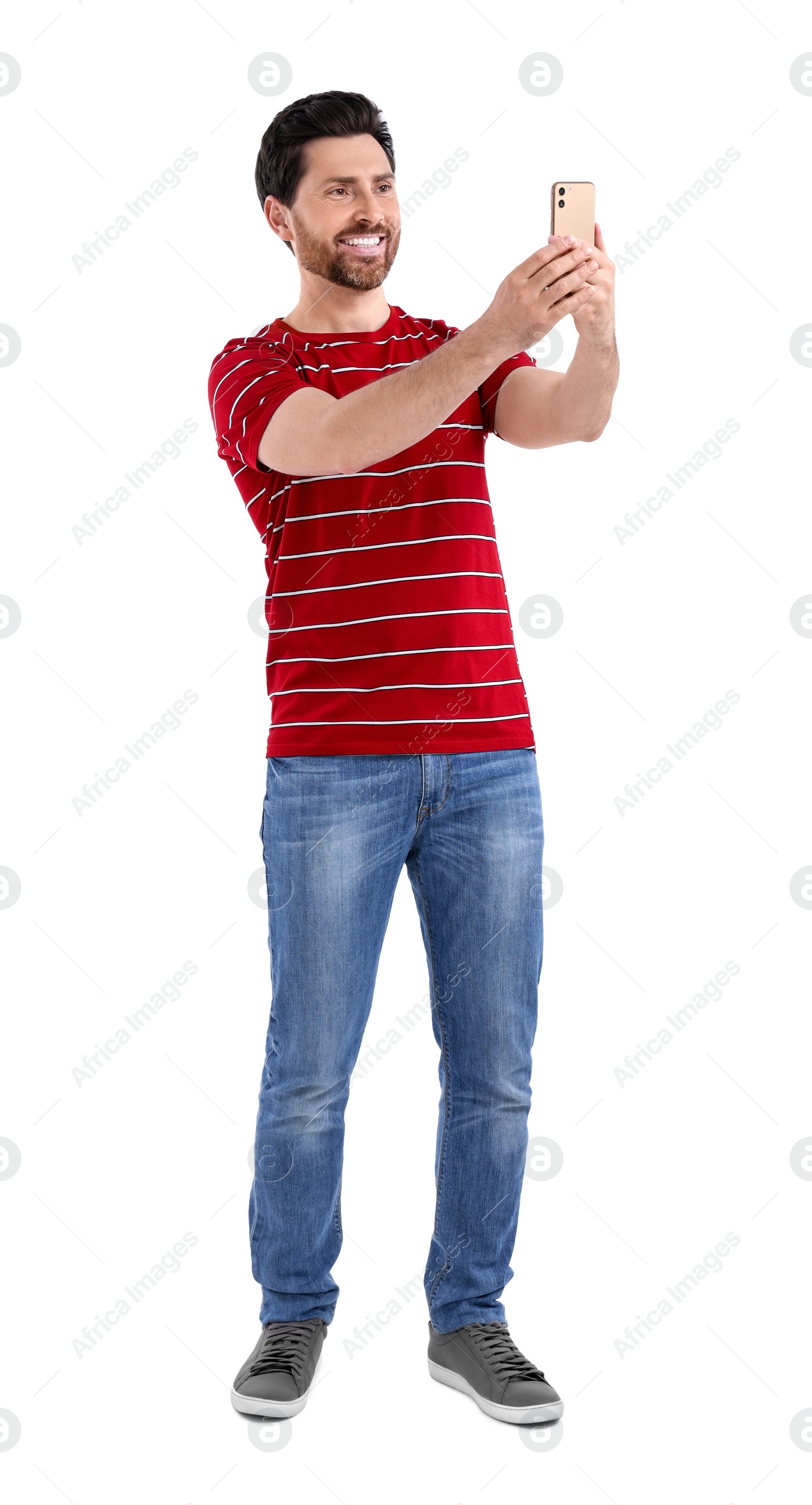 Photo of Smiling man taking selfie with smartphone on white background