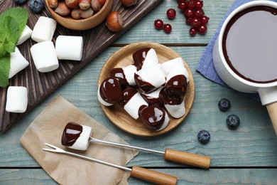 Photo of Delicious marshmallows covered with chocolate on wooden table, flat lay