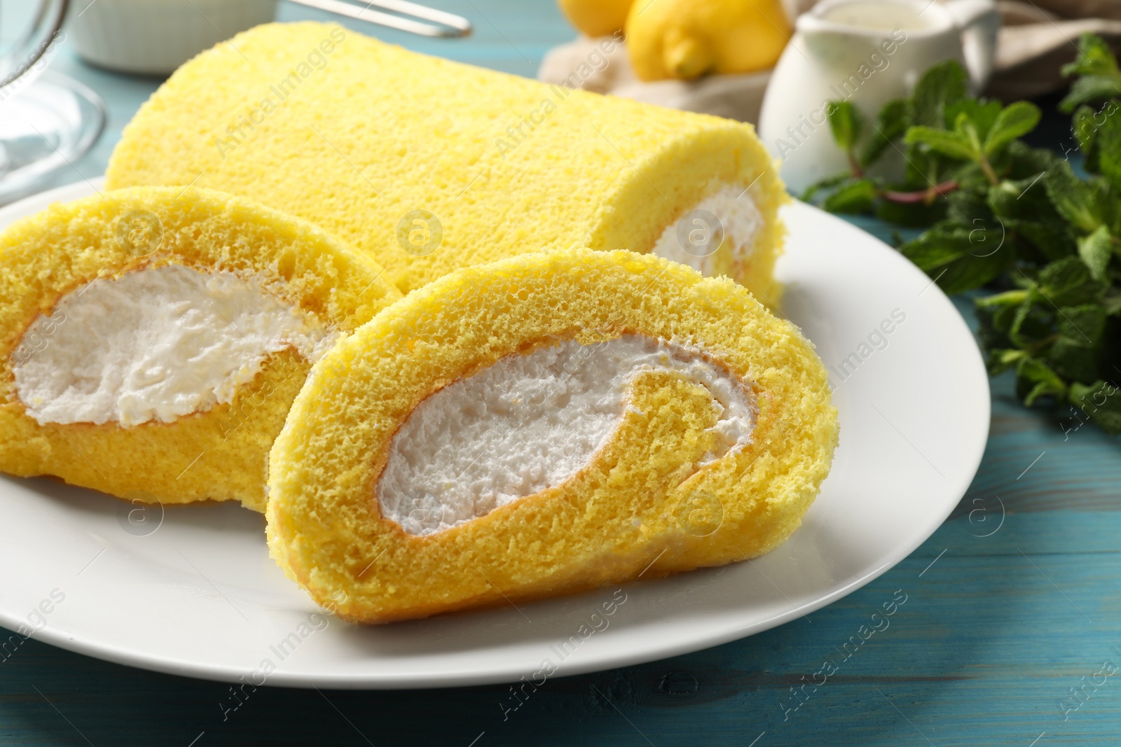 Photo of Delicious cake roll on light blue wooden table, closeup