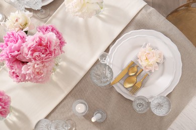 Photo of Stylish table setting with beautiful peonies and burning candles, flat lay