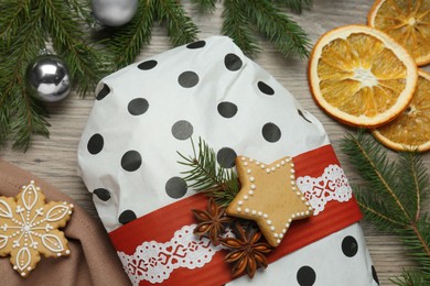 Photo of Wrapped Christmas Stollen with decoration on wooden table, flat lay