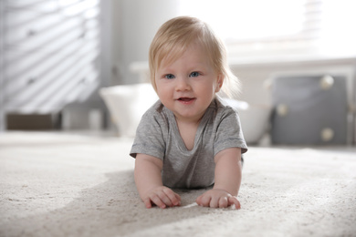 Photo of Adorable little baby on floor at home