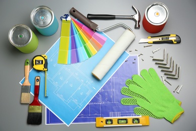 Photo of Set of decorator's tools and project drawings on grey background