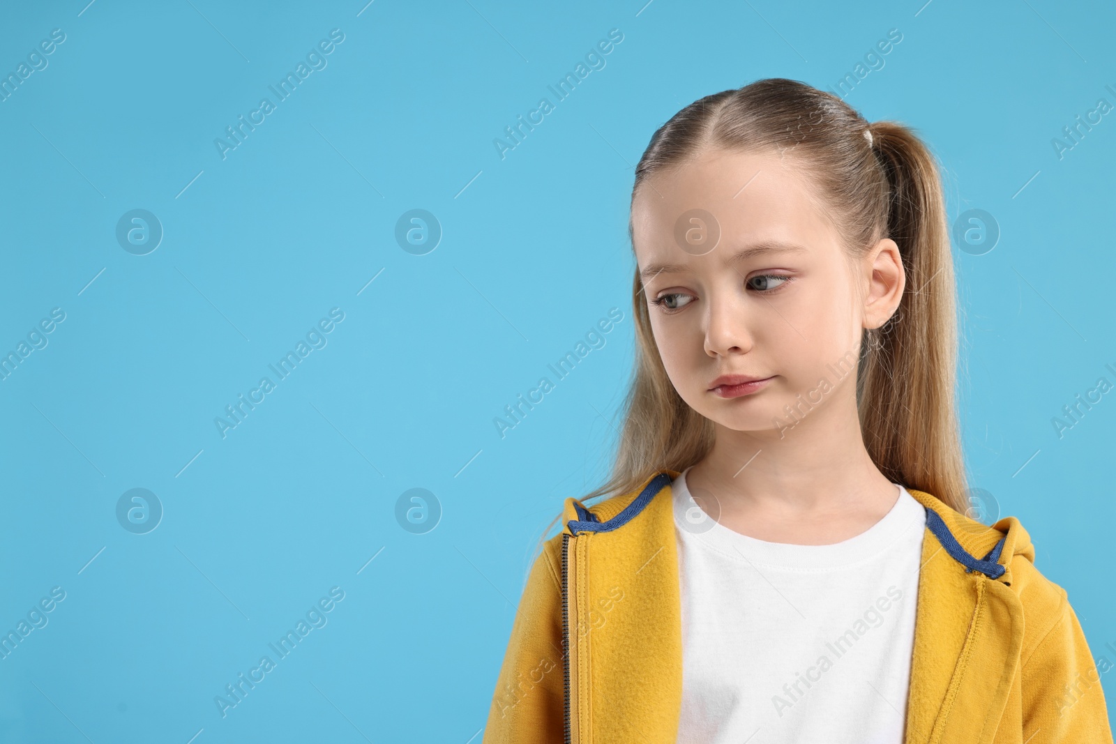 Photo of Portrait of sad girl on light blue background, space for text