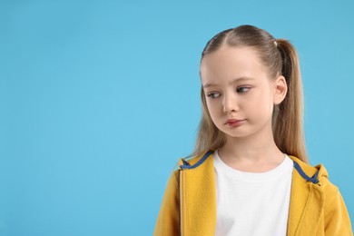 Photo of Portrait of sad girl on light blue background, space for text