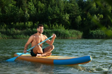 Photo of Man paddle boarding on SUP board in river