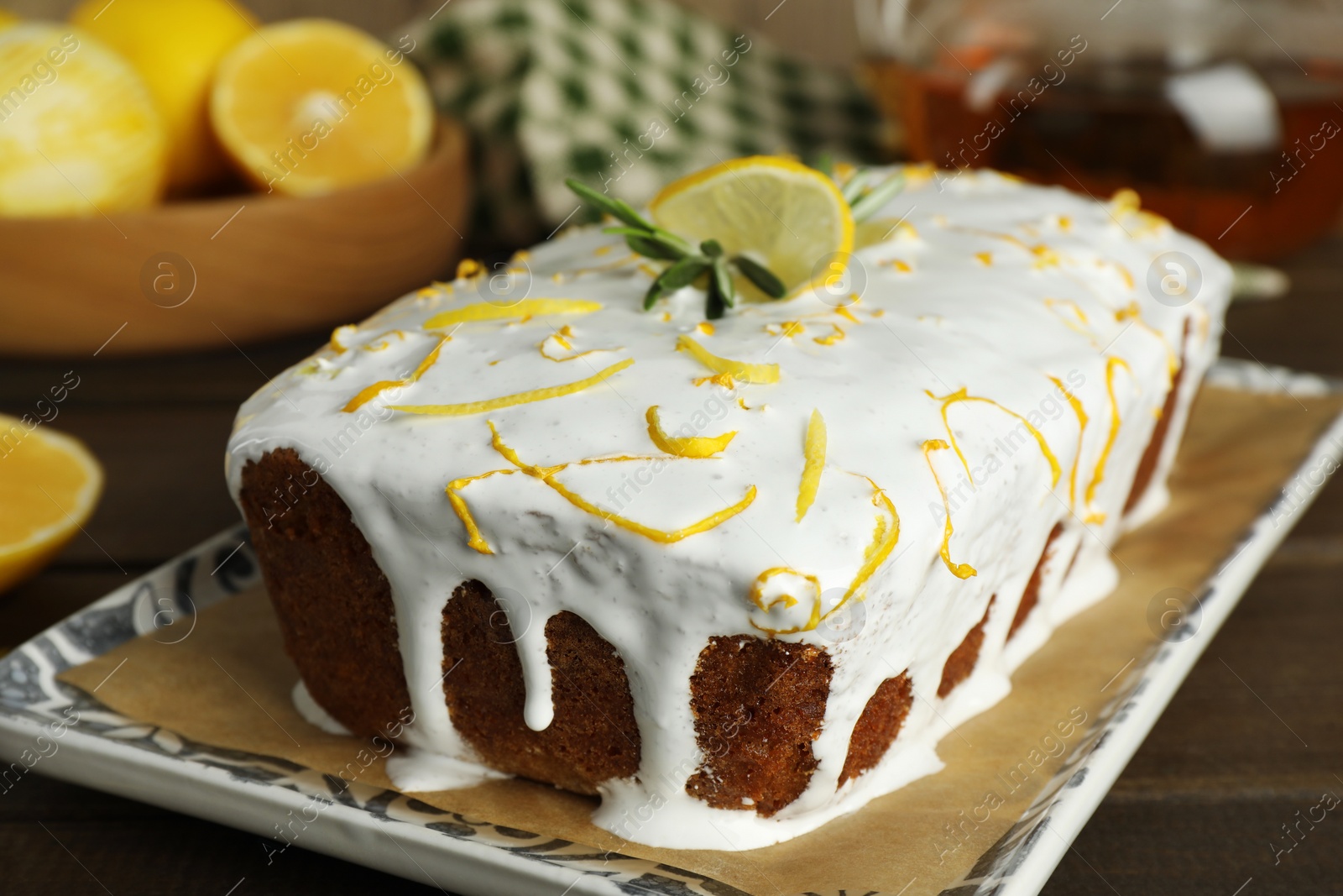 Photo of Tasty lemon cake with glaze on wooden table, closeup