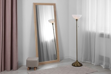 Photo of Stylish makeup room interior with long mirror and lamp