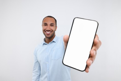 Young man showing smartphone in hand on white background