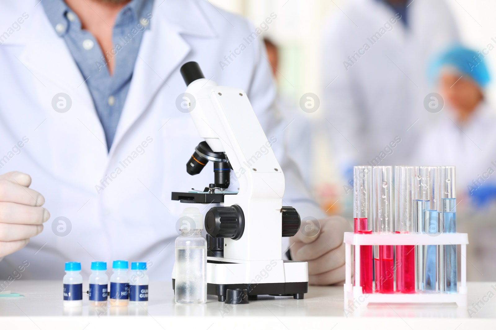 Photo of Scientist working with microscope in laboratory, closeup. Research and analysis