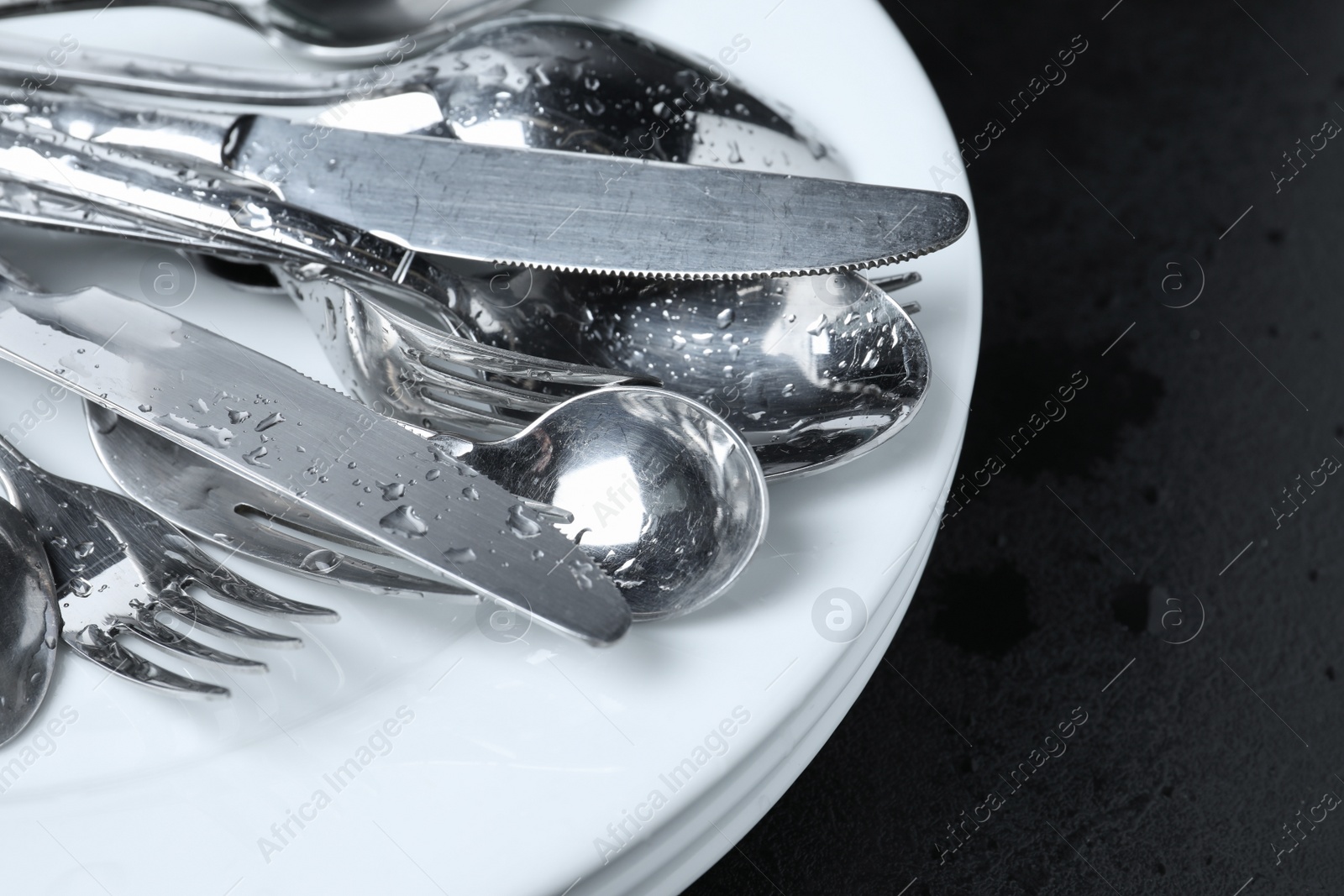 Photo of Different kitchenware after washing on black table, closeup. Space for text