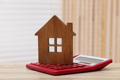 House model and calculator on wooden table