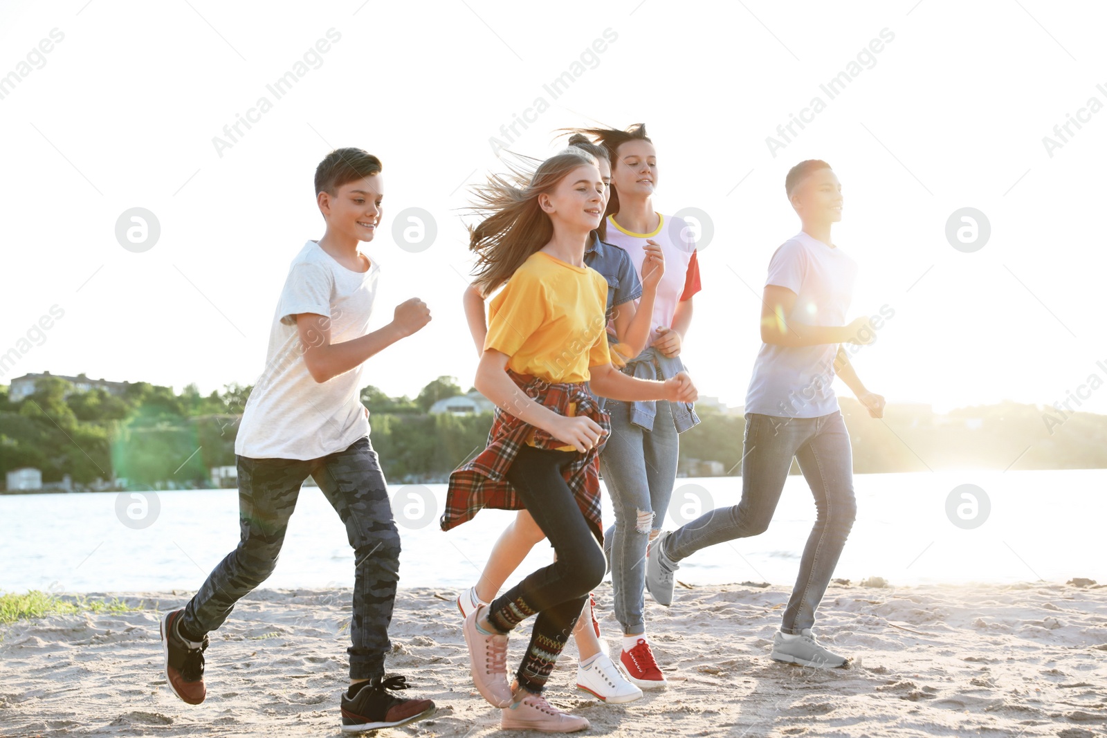 Photo of Group of children running on beach. Summer camp