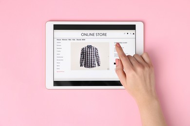 Photo of Woman with tablet shopping online on pink background, top view