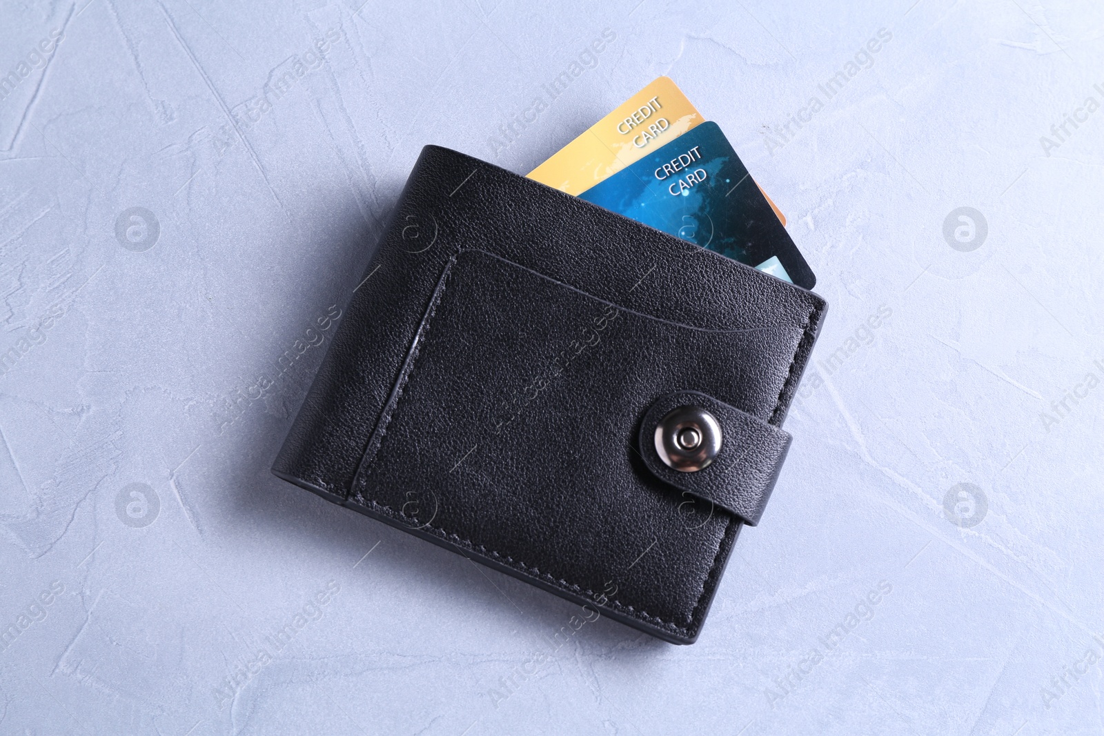 Photo of Credit cards in leather wallet on grey textured table, top view