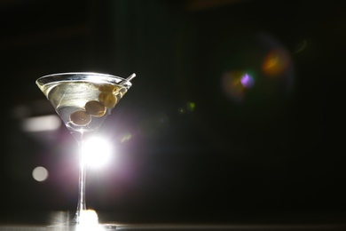 Photo of Glass of martini cocktail with olives in bar. Space for text