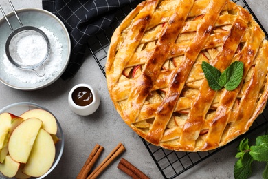 Flat lay composition with fresh traditional apple pie on light grey table