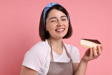Happy confectioner with cheesecake on pink background