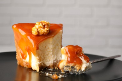 Piece of delicious cake with caramel and popcorn on plate, closeup. Space for text