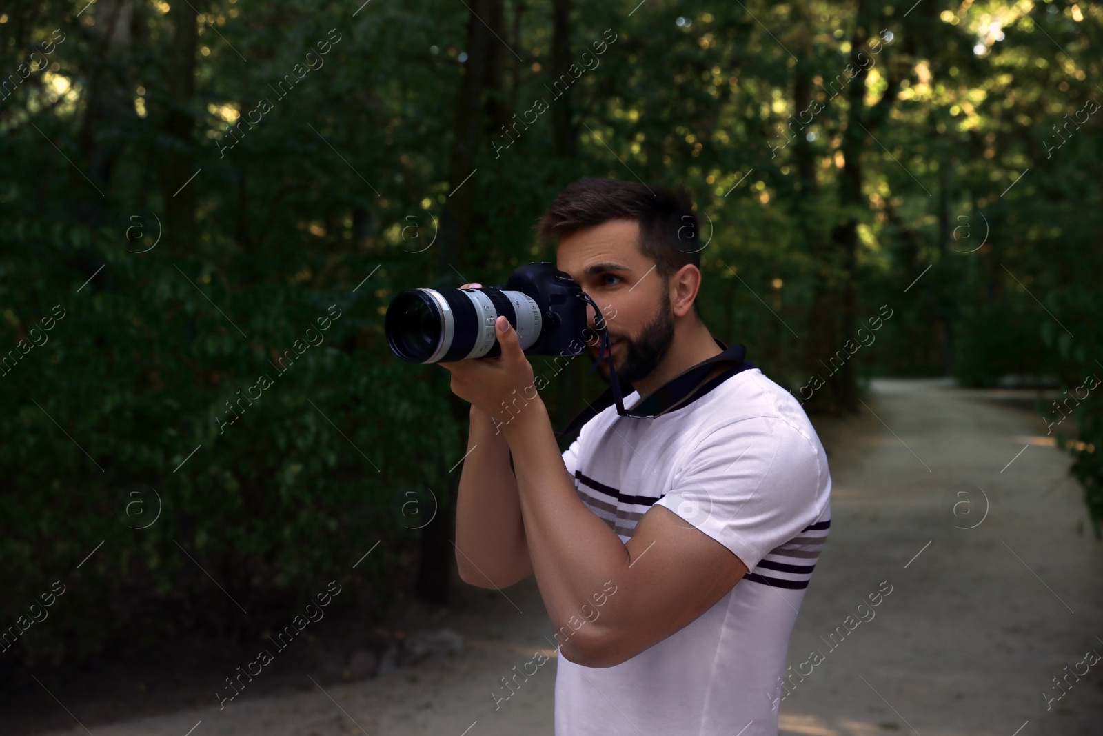 Photo of Handsome man with camera spending time in nature reserve