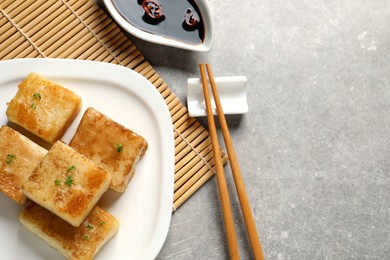 Photo of Delicious turnip cake served on grey table. Space for text