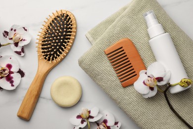 Photo of Flat lay composition with wooden hair brush and comb on white marble table