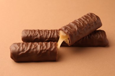 Sweet tasty chocolate bars with caramel on beige background