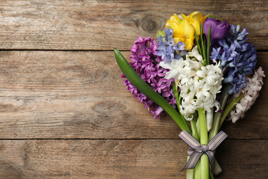 Photo of Beautiful spring flowers on wooden table, top view. Space for text