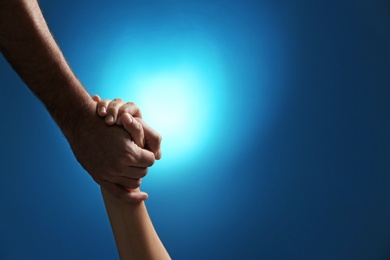 Man and woman holding hands on color background, closeup. Help and support concept