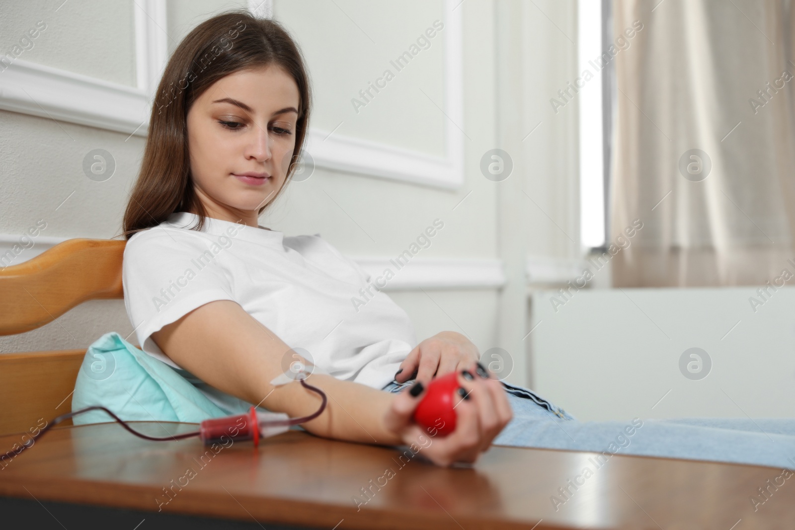 Photo of Teenage girl making blood donation in hospital