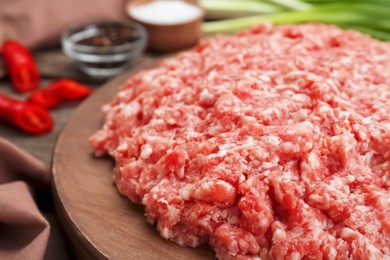 Photo of Board with raw fresh minced meat on wooden table, closeup