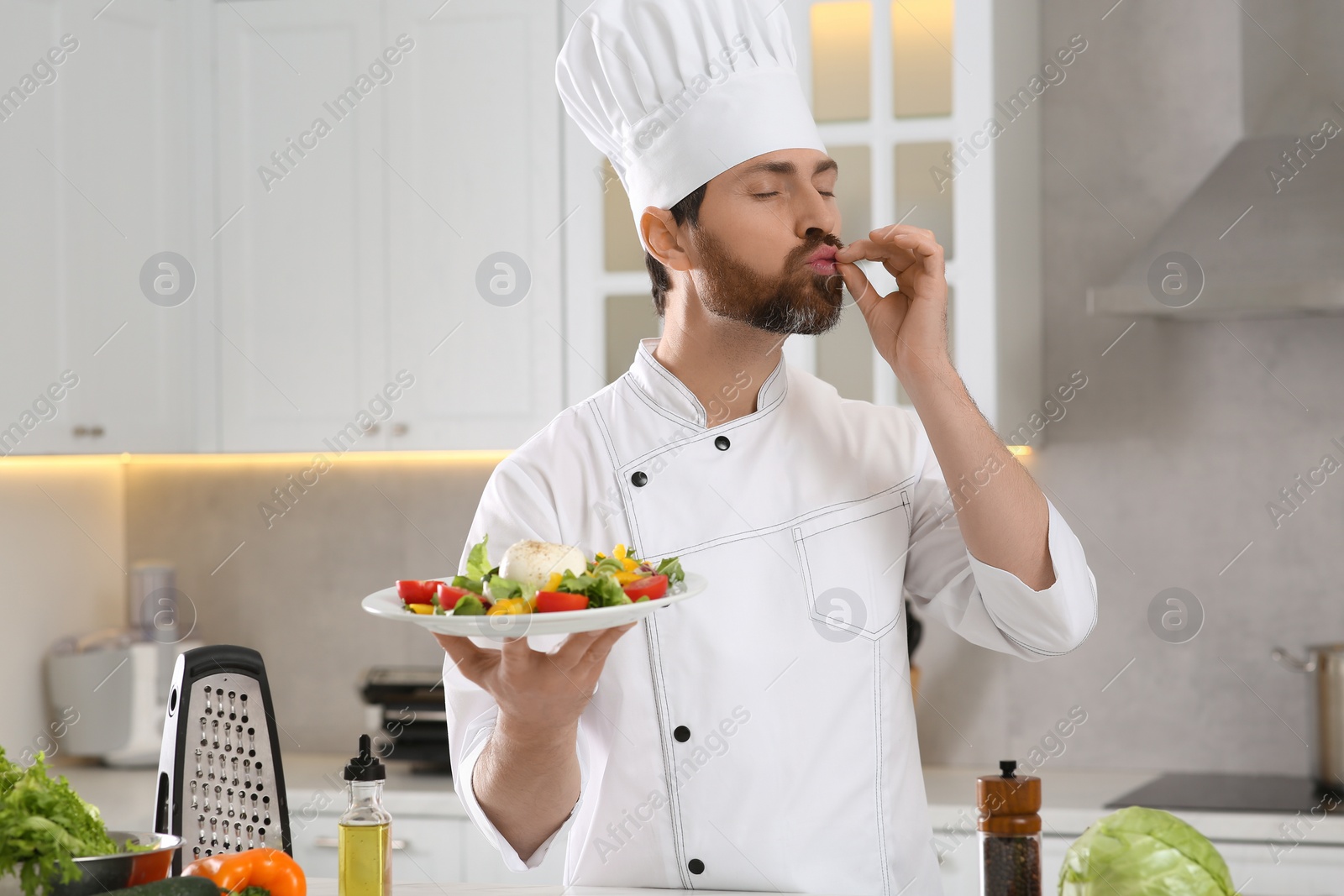 Photo of Professional chef presenting delicious salad in kitchen