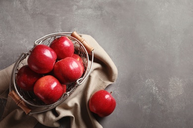 Basket with fresh ripe red apples on grey background